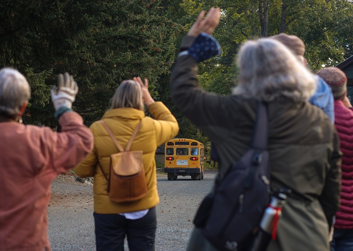 People waving farewell to the bus